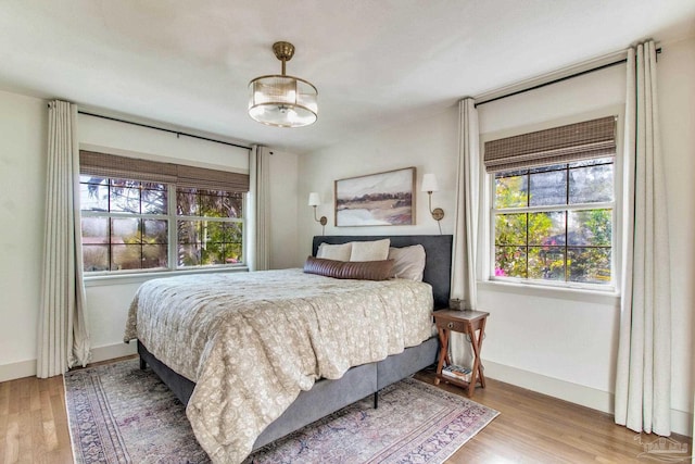 bedroom with baseboards and wood finished floors