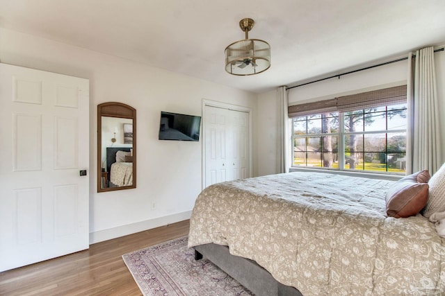 bedroom featuring a closet, baseboards, and wood finished floors