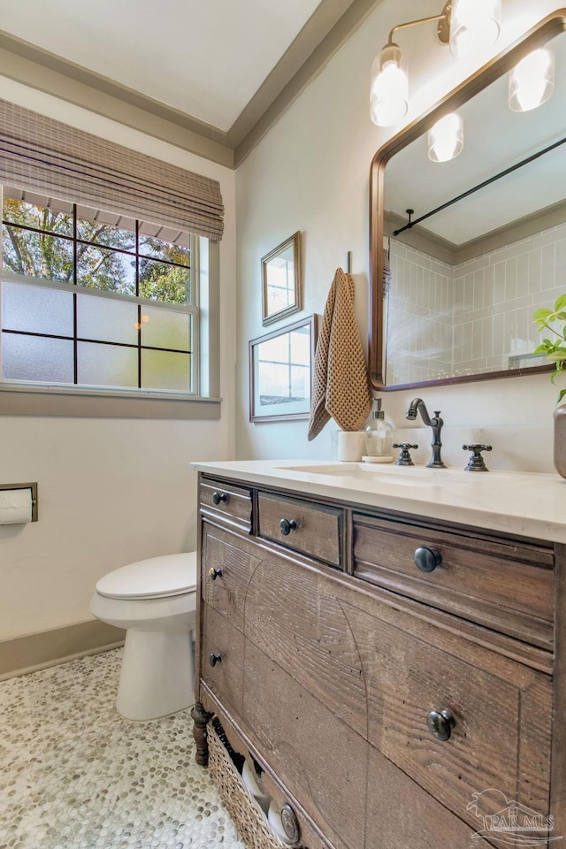 bathroom featuring vanity, baseboards, ornamental molding, tile patterned floors, and toilet