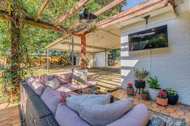 view of patio with a ceiling fan, an outdoor structure, outdoor lounge area, and fence