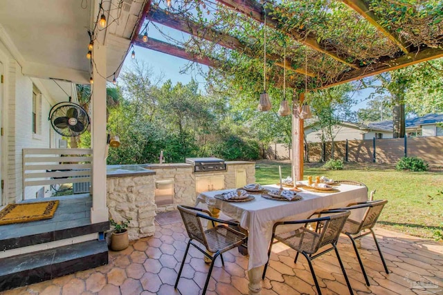 view of patio / terrace with outdoor dining space, an outdoor kitchen, grilling area, and fence