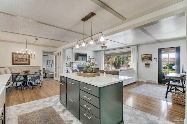 kitchen featuring light wood finished floors, a center island, decorative light fixtures, open floor plan, and an inviting chandelier