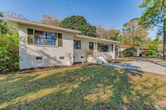 single story home featuring crawl space, brick siding, and a front lawn