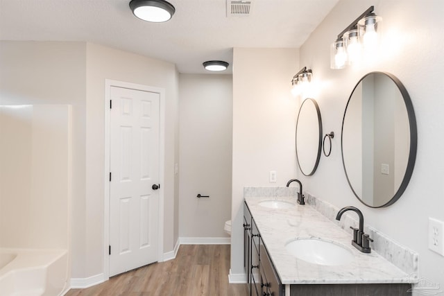 10104 Clearsound Dr, Pensacola, FL 32506 - bathroom with double vanity, wood finished floors, visible vents, and a sink