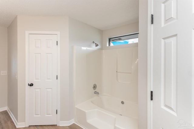 10104 Clearsound Dr, Pensacola, FL 32506 - full bathroom featuring baseboards, shower / bathtub combination, wood finished floors, and a textured ceiling