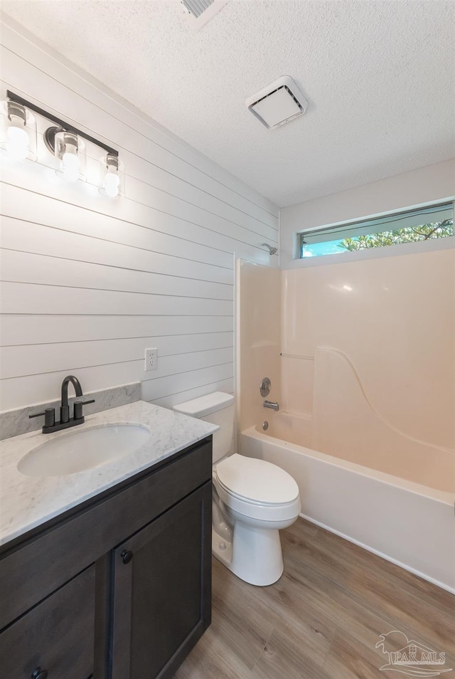10104 Clearsound Dr, Pensacola, FL 32506 - full bath featuring wooden walls, wood finished floors, vanity, shower / tub combination, and a textured ceiling