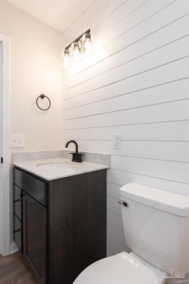 10104 Clearsound Dr, Pensacola, FL 32506 - half bathroom featuring toilet, vanity, and wood finished floors