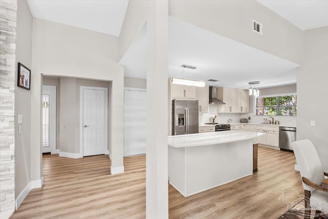 4308 Northpointe Way, Pensacola, FL 32514 - kitchen with appliances with stainless steel finishes, wall chimney range hood, light countertops, and light wood-style flooring