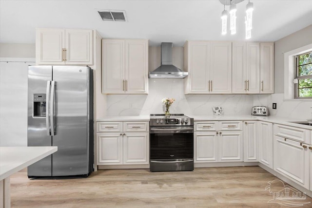 4308 Northpointe Way, Pensacola, FL 32514 - kitchen with appliances with stainless steel finishes, wall chimney range hood, light countertops, tasteful backsplash, and light wood-style floors