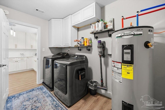 4308 Northpointe Way, Pensacola, FL 32514 - washroom featuring electric water heater, washer and clothes dryer, cabinet space, and light wood finished floors