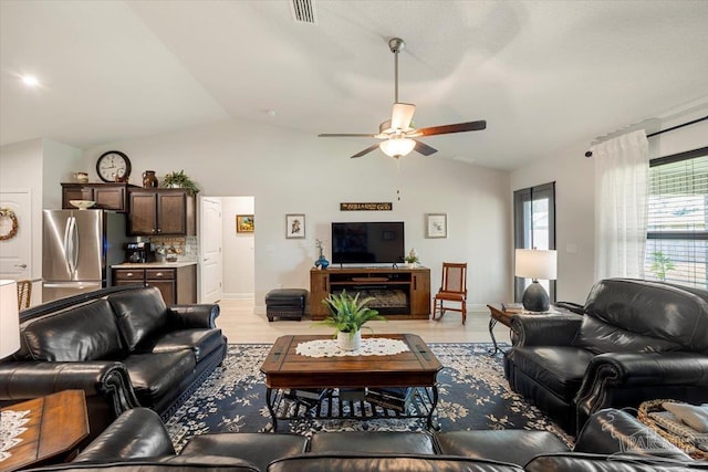 living room featuring vaulted ceiling, a ceiling fan, and light wood-style floors