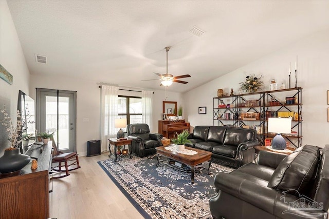 living area featuring lofted ceiling, light wood-style floors, and ceiling fan