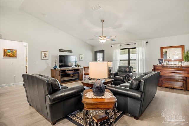 living area with light wood finished floors, ceiling fan, baseboards, and high vaulted ceiling