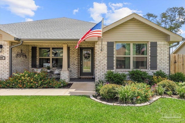 view of front of property with brick siding, a porch, and a shingled roof