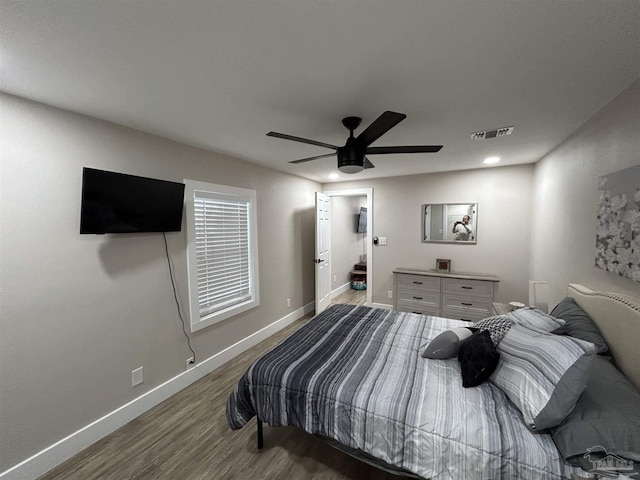 bedroom with dark hardwood / wood-style flooring and ceiling fan