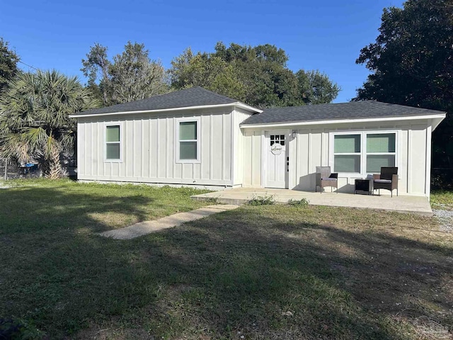 rear view of property featuring a yard and a patio