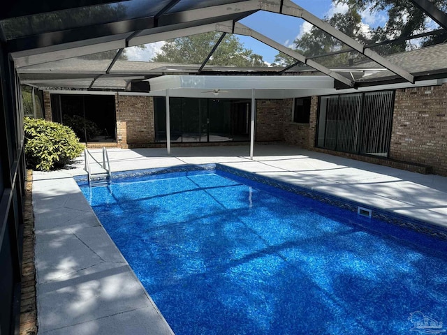 view of swimming pool featuring a lanai and a patio area