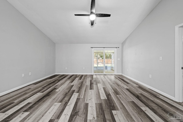 empty room featuring lofted ceiling, ceiling fan, and hardwood / wood-style flooring