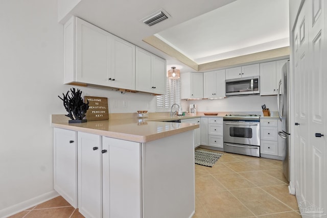 kitchen with light tile patterned floors, visible vents, appliances with stainless steel finishes, a peninsula, and white cabinetry