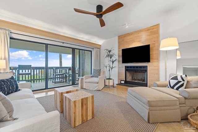 tiled living area featuring ceiling fan and a fireplace