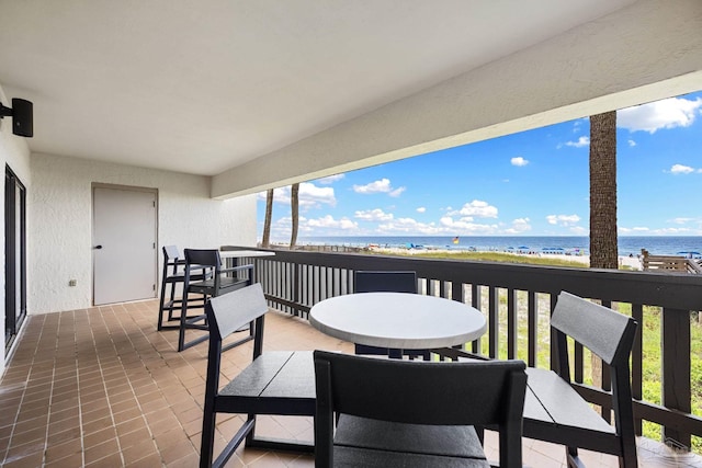 balcony featuring a view of the beach and a water view