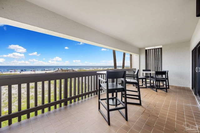 balcony featuring a water view and a beach view