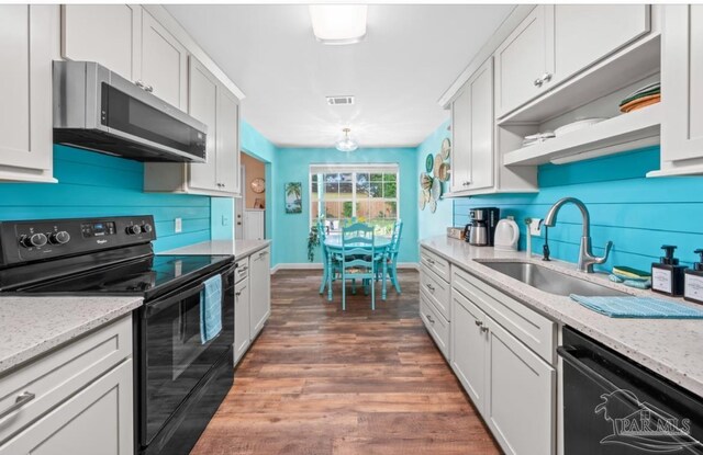 7837 Skyview Blvd, Navarre, FL 32566 - kitchen with black electric range, stainless steel microwave, dishwashing machine, and decorative backsplash