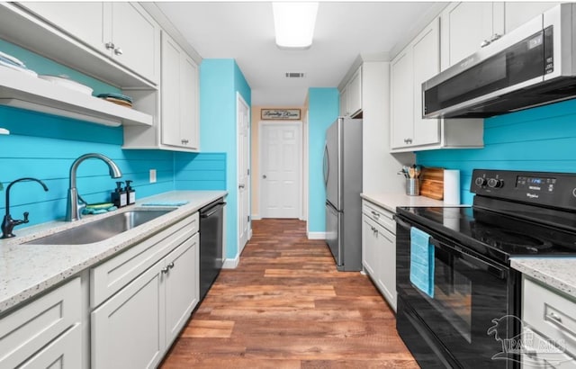 7837 Skyview Blvd, Navarre, FL 32566 - kitchen with black appliances, white cabinets, wood finished floors, decorative backsplash, and open shelves