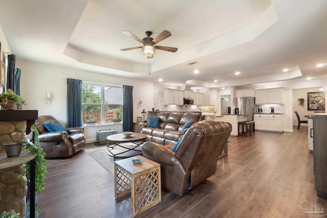 2849 Pga Blvd, Navarre, FL 32566 - living room featuring a raised ceiling, ceiling fan, dark wood-style flooring, recessed lighting, and baseboards
