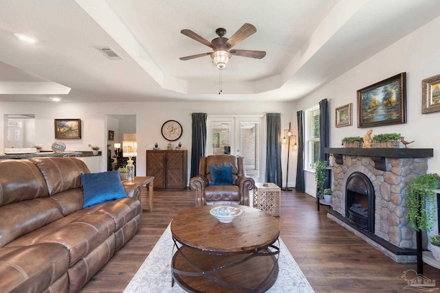 2849 Pga Blvd, Navarre, FL 32566 - living area with a tray ceiling, ceiling fan, dark wood-type flooring, a fireplace, and baseboards