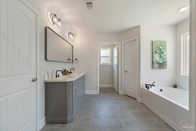 2849 Pga Blvd, Navarre, FL 32566 - full bathroom with double vanity, tile patterned floors, a bath, and baseboards