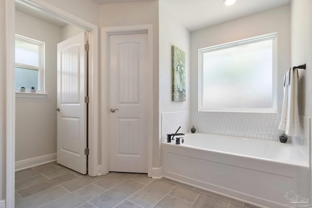 2849 Pga Blvd, Navarre, FL 32566 - bathroom featuring a garden tub and tile patterned floors