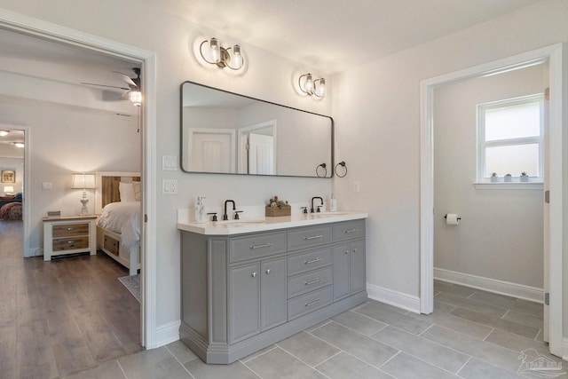 2849 Pga Blvd, Navarre, FL 32566 - ensuite bathroom featuring double vanity, baseboards, and wood finished floors