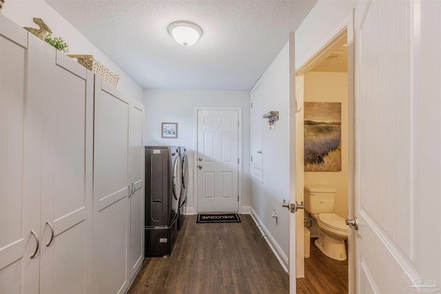 2849 Pga Blvd, Navarre, FL 32566 - laundry area with washer and clothes dryer, dark wood finished floors, a textured ceiling, and baseboards