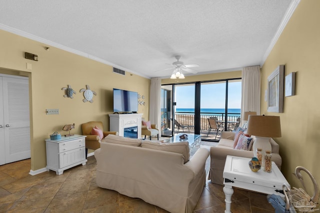 living room with ceiling fan, a textured ceiling, and ornamental molding