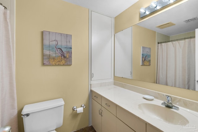 bathroom with toilet, vanity, and walk in shower