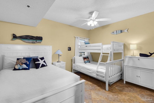 bedroom with ceiling fan and a textured ceiling