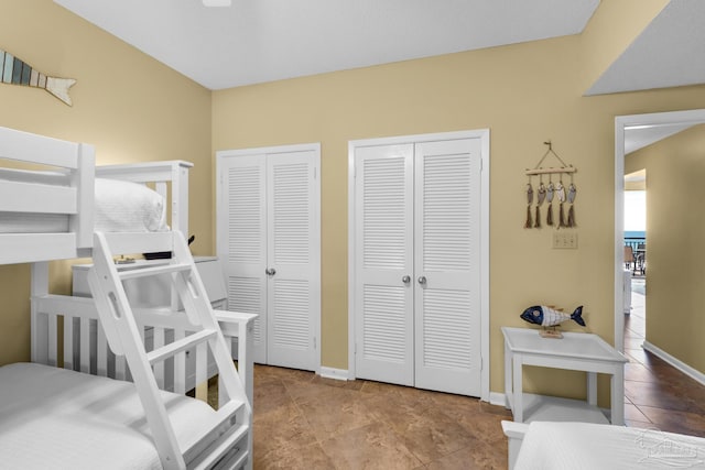 bedroom with light tile patterned floors and two closets