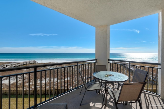 balcony featuring a water view and a beach view