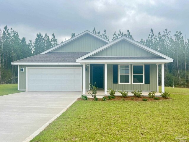 9344 Three Hollow Rd, Jay, FL 32565 - view of front facade featuring an attached garage, a porch, driveway, a shingled roof, and a front lawn