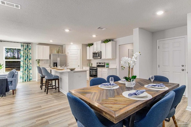 9344 Three Hollow Rd, Jay, FL 32565 - dining room with light wood-type flooring, a textured ceiling, recessed lighting, and baseboards