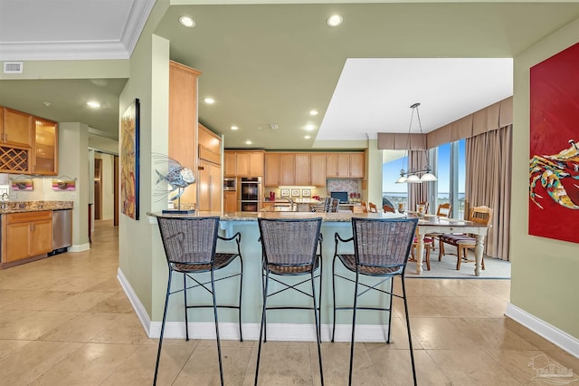 kitchen featuring appliances with stainless steel finishes, ornamental molding, a kitchen breakfast bar, kitchen peninsula, and decorative backsplash