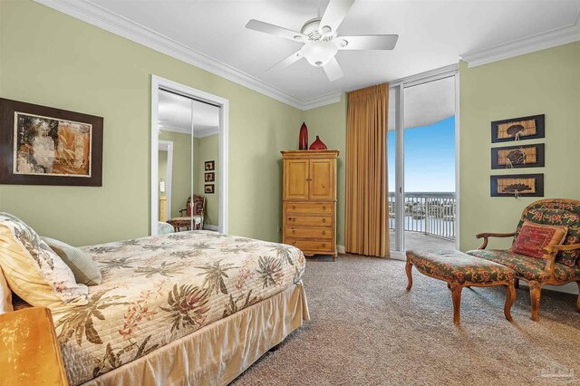 bedroom featuring a water view, access to outside, ornamental molding, carpet flooring, and a wall of windows