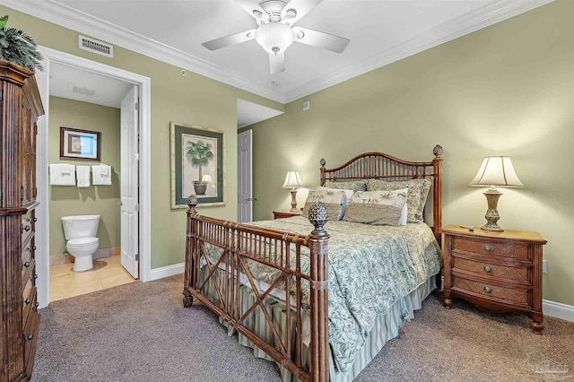 carpeted bedroom with ornamental molding, ceiling fan, and ensuite bath
