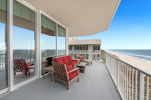 balcony featuring a view of the beach and a water view