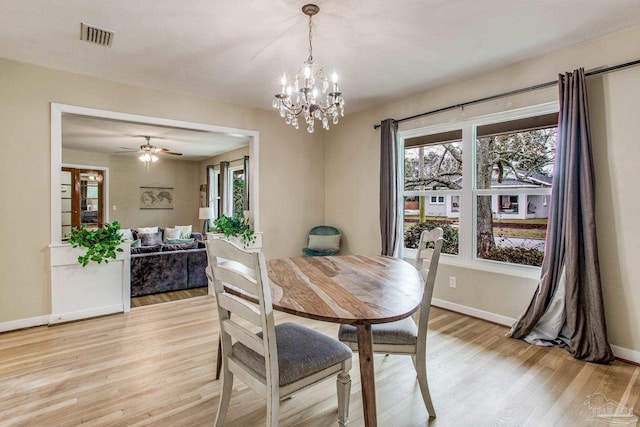 dining area with ceiling fan with notable chandelier and light hardwood / wood-style floors