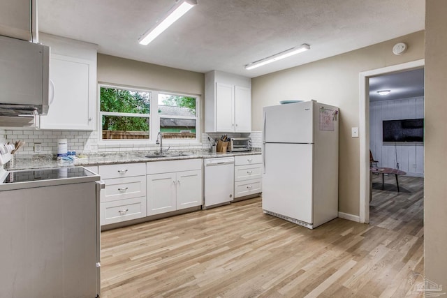 kitchen with white appliances, sink, decorative backsplash, and white cabinets