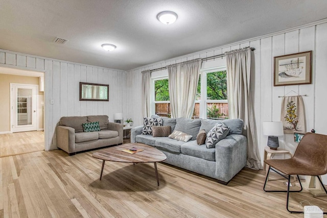 living room featuring light hardwood / wood-style floors and a textured ceiling