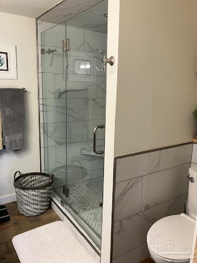 4316 Floridatown Rd, Pace, FL 32571 - bathroom featuring a shower stall, toilet, wood finished floors, and tile walls
