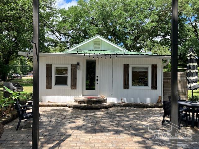 4316 Floridatown Rd, Pace, FL 32571 - view of front of home featuring a patio, metal roof, and outdoor dining area